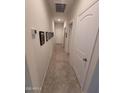 Bright hallway with tile flooring, white walls, and doors along the sides, leading to other rooms at 1133 E Viola Ct, Casa Grande, AZ 85122