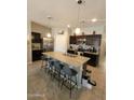 Spacious kitchen featuring a large island with bar seating, dark cabinets, and stainless steel appliances at 1133 E Viola Ct, Casa Grande, AZ 85122