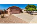 A cozy home with desert landscaping and a spacious two-car garage and concrete driveway at 11338 E Contessa St, Mesa, AZ 85207