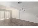 Open-concept dining space with wood-look floors and a modern white chandelier at 122 S Hardy Dr # 62, Tempe, AZ 85281