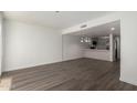 Open-concept living area with wood-look floors and views of the kitchen with white counter at 122 S Hardy Dr # 62, Tempe, AZ 85281