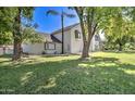 Wide lawn with trees surrounding the home's exterior, showcasing the white painted brick and bay windows at 1712 E Fairfield St, Mesa, AZ 85203