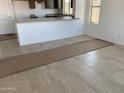 Spacious living room with tile flooring, bright white walls and a large opening to the kitchen at 32016 N Pony Express Rd, San Tan Valley, AZ 85143