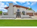 Inviting home featuring a well-kept lawn and an elegant entrance with decorative wrought iron gate at 4601 E Carolina Dr, Phoenix, AZ 85032