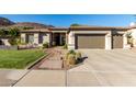 Charming home with a well-manicured front yard, desert landscaping, and a three-car garage, set against a mountainous backdrop at 4618 W Pokeberry Ln, Phoenix, AZ 85083