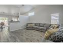 Open-concept living room featuring high ceilings, hardwood flooring, and a comfortable gray sofa at 7930 W Colter St, Glendale, AZ 85303