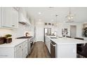 Spacious kitchen with stainless steel appliances, a large island, and wood-look tile flooring at 8012 W Griswold Rd, Peoria, AZ 85345
