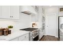 Modern white kitchen features stainless steel appliances, a gas range, and ample cabinet space at 8012 W Griswold Rd, Peoria, AZ 85345