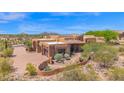 Expansive desert home with a terracotta facade, landscaped front yard, and mountain views at 8154 E Tecolote Cir, Scottsdale, AZ 85266