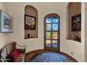 Inviting foyer with decorative tile flooring, arched doorway, and bench seating at 8154 E Tecolote Cir, Scottsdale, AZ 85266