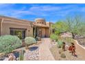 Charming home entrance with a brick walkway, desert landscaping, and an arched wooden door at 8154 E Tecolote Cir, Scottsdale, AZ 85266