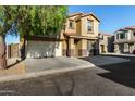 Two story home with a two-car garage, desert landscaping, and a tiled roof at 9415 W Eaton Rd, Phoenix, AZ 85037
