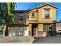 Two story home with a two-car garage, desert landscaping, and a tiled roof at 9415 W Eaton Rd, Phoenix, AZ 85037