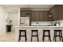 Modern kitchen features an island with seating and stainless steel appliances at 9522 W Avalon Dr, Phoenix, AZ 85037
