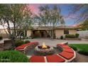 Inviting backyard with a stone fire pit and built-in seating, perfect for entertaining and enjoying outdoor evenings at 11193 N 121St Way, Scottsdale, AZ 85259