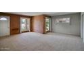 Spacious carpeted living room featuring large windows and brick accents at 12220 N 22Nd Pl, Phoenix, AZ 85022