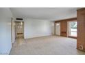 Bright living room with a large window, neutral carpet, and brick accents at 12220 N 22Nd Pl, Phoenix, AZ 85022