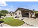 Spacious backyard featuring a putting green, covered patio, and lush desert landscaping at 12732 S 175Th Dr, Goodyear, AZ 85338