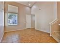 Bright living room with high ceilings, tile flooring, and a view to the outside at 14870 W Encanto Blvd # 1038, Goodyear, AZ 85395