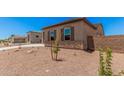 Side view of a single-story home featuring desert landscaping, a brick perimeter wall and a three-car garage at 17308 W Royal Palm Rd, Waddell, AZ 85355