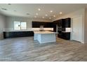Spacious kitchen boasts a large center island, black cabinets, and stainless appliances at 17308 W Royal Palm Rd, Waddell, AZ 85355