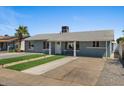View of a single story home with manicured front yard, gravel landscaping and concrete driveway at 2036 W Windrose Dr, Phoenix, AZ 85029