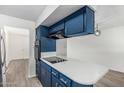 Well-equipped kitchen featuring a cooktop island, upper and lower blue cabinets, and modern finishes at 2117 W 2Nd St, Mesa, AZ 85201