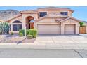 Charming home featuring a tile roof, arched entry, desert landscaping, and a three-car garage at 22019 N 59Th Dr, Glendale, AZ 85310