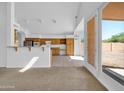 Open-concept kitchen featuring wood cabinetry and a breakfast bar leading to dining and living area at 22019 N 59Th Dr, Glendale, AZ 85310