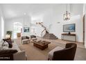 Open-concept living room with high ceilings, staircase, and views into the kitchen area at 22019 N 59Th Dr, Glendale, AZ 85310