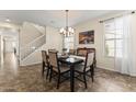 Traditional dining room featuring a chandelier, staircase, and tiled flooring with a window at 2213 N Park Meadows Dr, Buckeye, AZ 85396