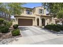 Charming two-story home with arched entryway, brown garage door, and mature landscaping at 2213 N Park Meadows Dr, Buckeye, AZ 85396