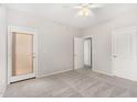Bright bedroom with carpet, ceiling fan, and multiple doors for closet and hallway access at 2311 E Hartford Ave # 29, Phoenix, AZ 85022