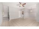 Open-concept living room featuring neutral paint, tile floors, stairs, and modern ceiling fan at 2311 E Hartford Ave # 29, Phoenix, AZ 85022