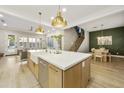 Open concept kitchen featuring a large island with a farmhouse sink and views into the living spaces at 2501 S Roanoke St, Gilbert, AZ 85295