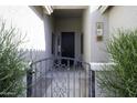 Charming gated front porch showcasing desert landscaping and a decorative front door at 2512 E Katrina Trl, Casa Grande, AZ 85194