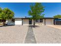 Charming single-story home with a well-maintained front yard featuring desert landscaping and a lovely tree at 313 N 101St Way, Mesa, AZ 85207