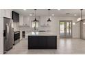 Spacious kitchen featuring white cabinets, a black island with marble countertop, and access to the backyard at 313 N 101St Way, Mesa, AZ 85207