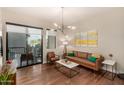 Cozy living room featuring hardwood floors, a modern light fixture, and a balcony view at 3131 N Central Ave # 3004, Phoenix, AZ 85012