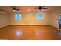 Spacious bonus room featuring tile flooring, two ceiling fans and natural light from a sliding glass door at 3734 W Dailey St, Phoenix, AZ 85053
