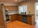 Kitchen view with tile floors, knotty pine cabinetry, stainless appliances, and backyard access at 3734 W Dailey St, Phoenix, AZ 85053