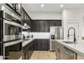 Stylish kitchen featuring modern appliances, dark cabinets, and bright countertops at 40614 N Harbour Town Ct, Anthem, AZ 85086