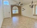 Bright living room with tile floors, arched windows, ceiling fan, and neutral paint, offering a versatile space at 4224 E Renee Dr, Phoenix, AZ 85050