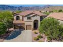 Charming two-story home featuring a tile roof, three-car garage, and landscaped front yard with mountain views at 4264 S Columbine Way, Gold Canyon, AZ 85118