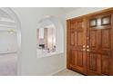 Entryway displaying wood double doors, arched doorway looking into the living room with a stone fireplace at 6719 W Kerry Ln, Glendale, AZ 85308