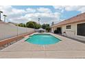 Backyard pool area with a blue pool, concrete surround, privacy wall and outdoor seating and lounge areas at 6719 W Kerry Ln, Glendale, AZ 85308