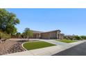 Charming single-story home featuring lush landscaping, a three-car garage, and a paved driveway at 6917 E Ingram Cir, Mesa, AZ 85207