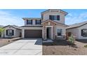Beautiful home with a two-car garage, stone accents, and neutral exterior paint under a clear blue sky at 7327 S 76Th Ln, Laveen, AZ 85339