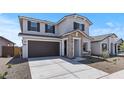 Inviting home featuring a spacious driveway, two-car garage, stone details, and a manicured front landscape at 7327 S 76Th Ln, Laveen, AZ 85339