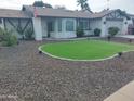 Nicely landscaped front yard with decorative rock, lawn, and brick accents enhancing the home's curb appeal at 8879 E Friess Dr, Scottsdale, AZ 85260